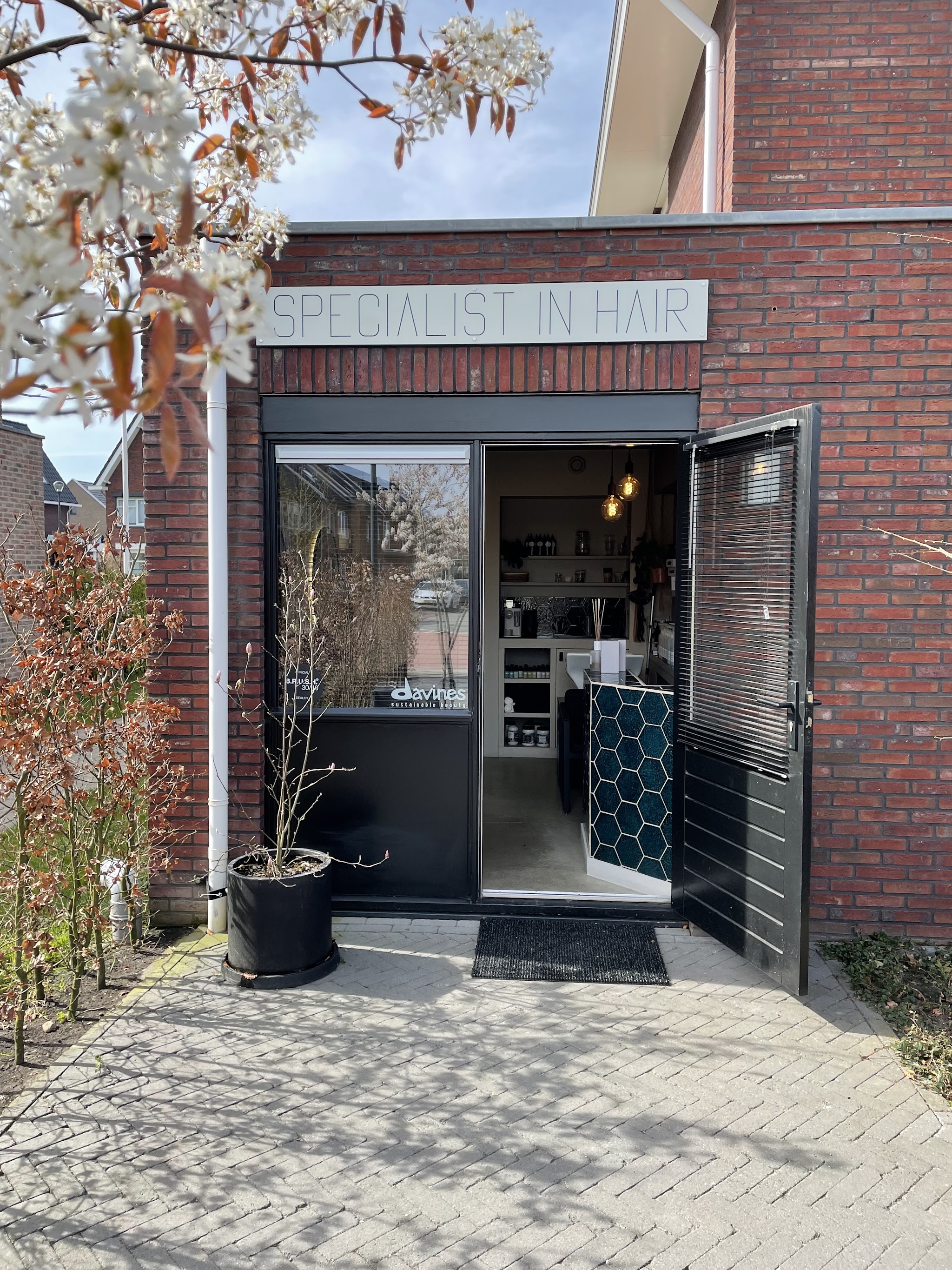 De ingang van de salon met het bord Specialist in Hair aan Zomerbed 52